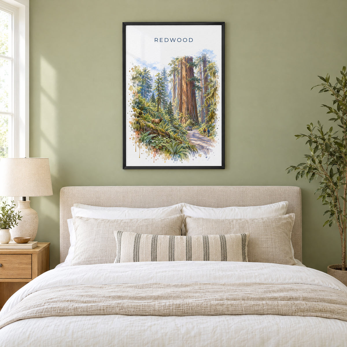 Redwood National Park watercolor print in a black frame above an upholstered headboard in a sage green bedroom