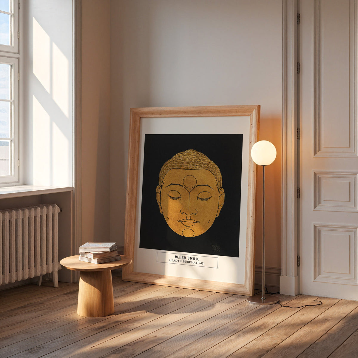 Stolk Buddha print in a wide pine frame leaning by a sunlit window