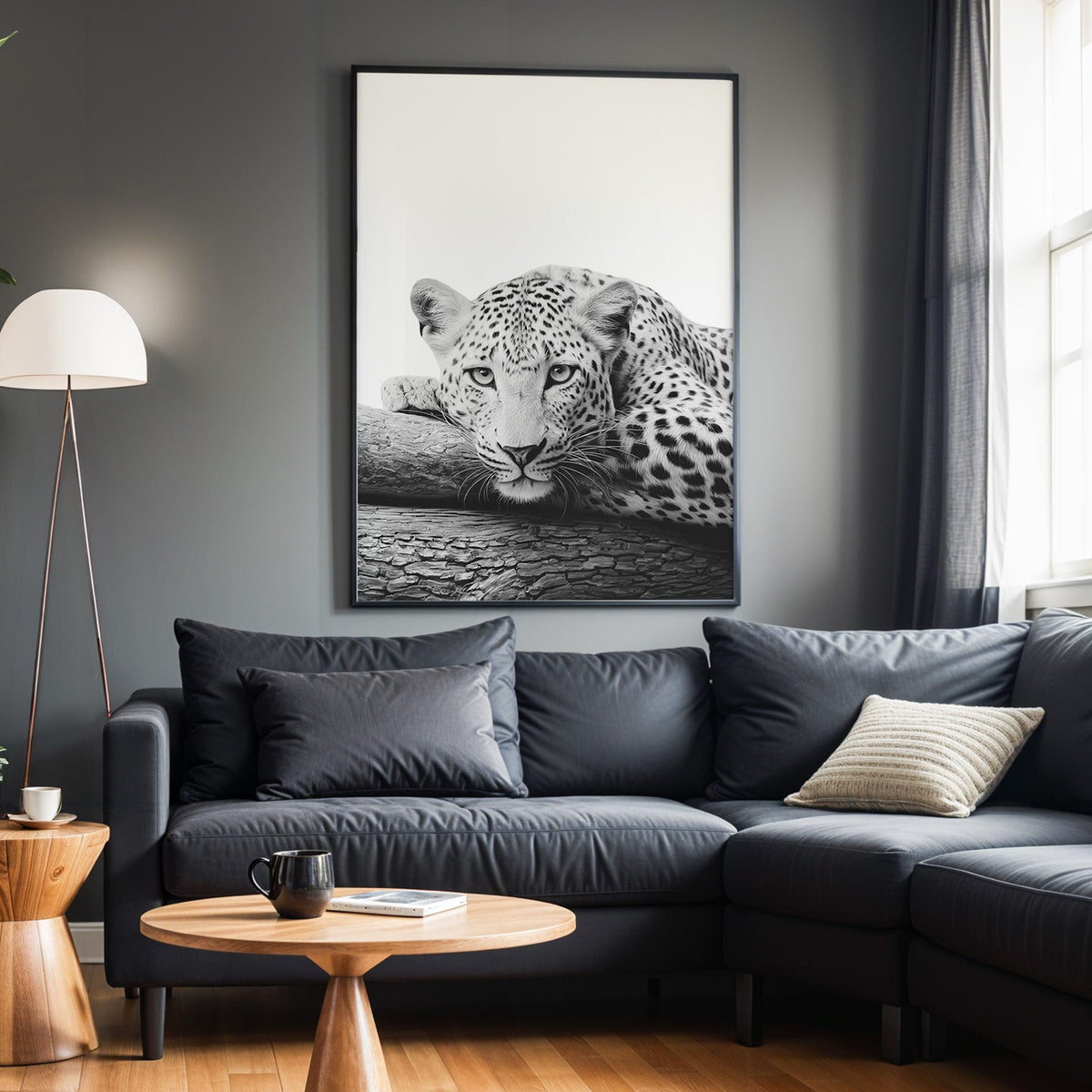 Text-free leopard chin on cracked log black and white print in a black frame above a charcoal sofa on a grey wall