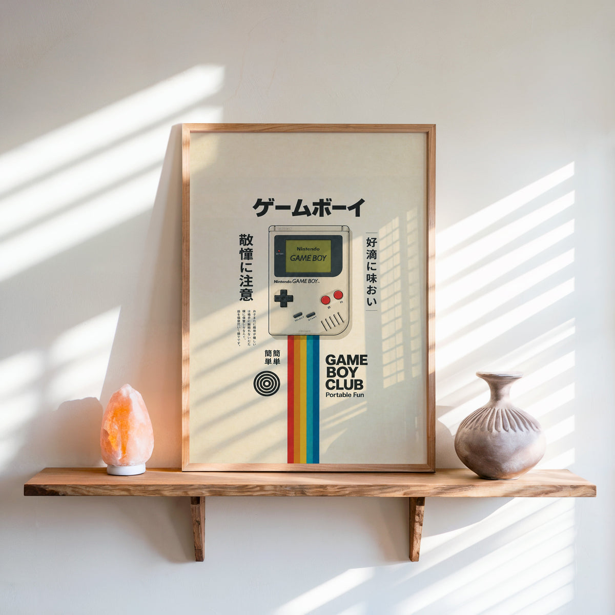 retro handheld game console with rainbow print in an oak frame on a live-edge wall shelf with a salt lamp and clay vase