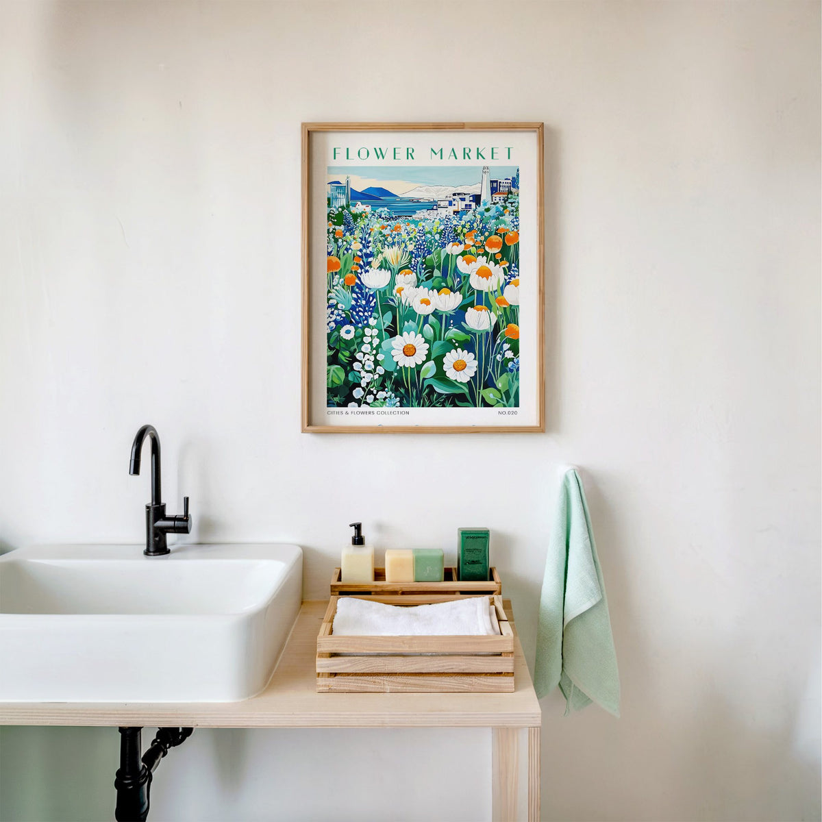 Reykjavik flower market print in an oak frame above a white bathroom sink with folded towels