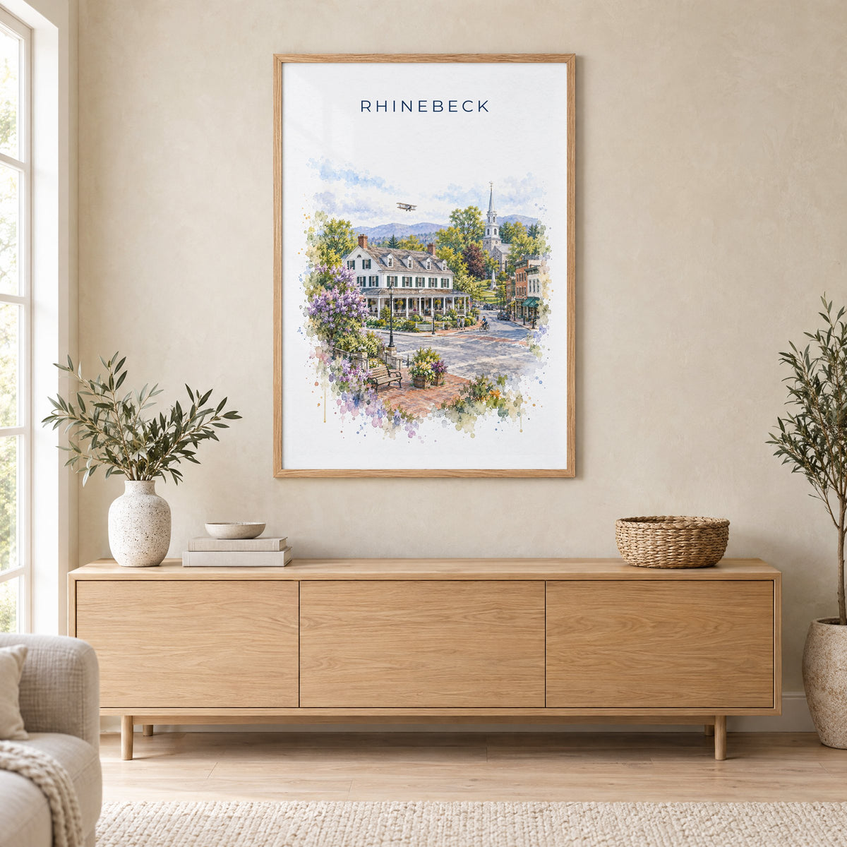 Rhinebeck, New York watercolor print in an oak frame above a light wood sideboard in a Scandinavian living room