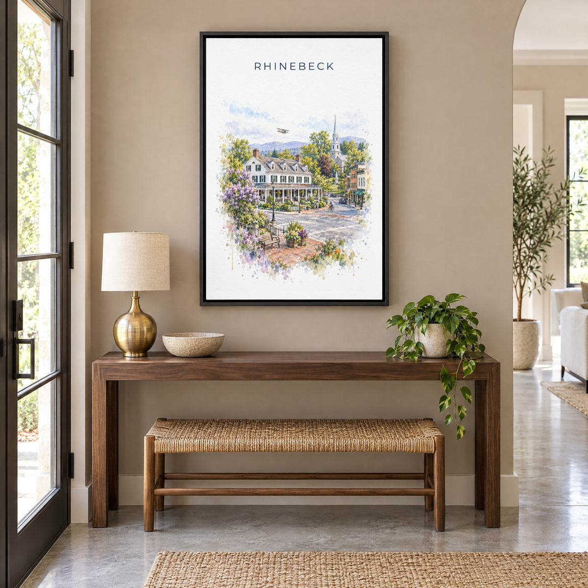 Rhinebeck, New York watercolor print as a black floater canvas above a walnut console and woven bench in an entryway
