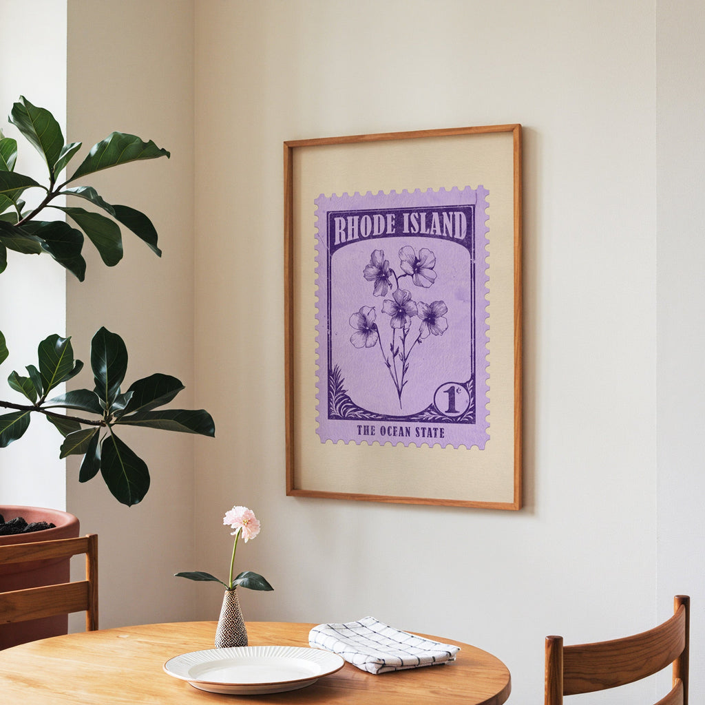 Rhode Island state flower print framed above a round wooden table with a single bloom in a vase and books