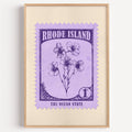 Rhode Island state flower stamp print in violet on lavender, light oak frame on a plain white wall