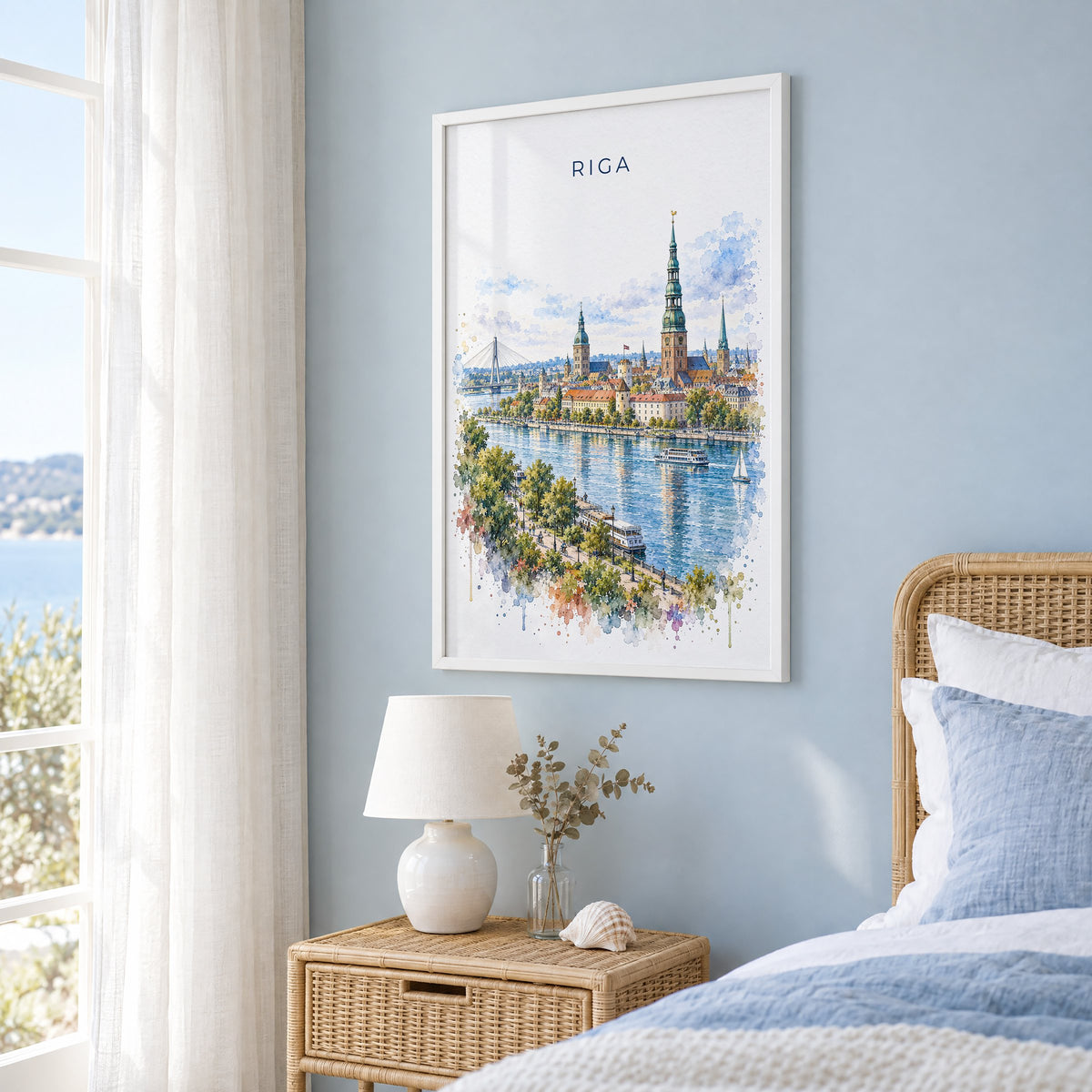 Riga watercolor print in a white frame on a pale blue wall beside a rattan bed in a coastal bedroom