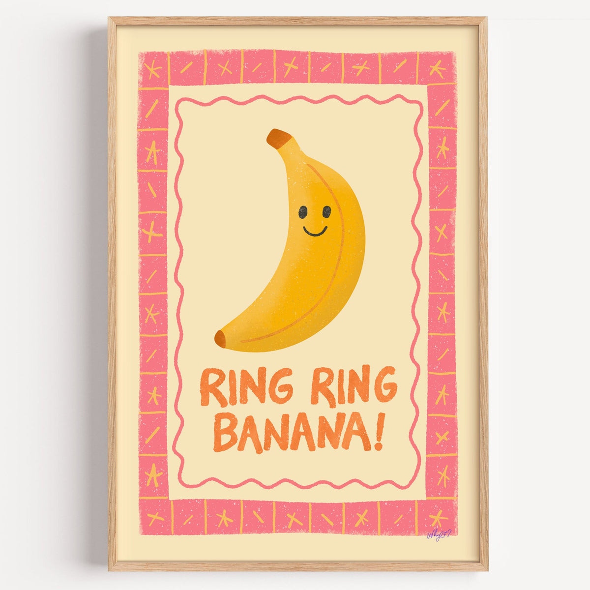 Smiling banana pink border nursery print in a light oak frame on a plain white wall