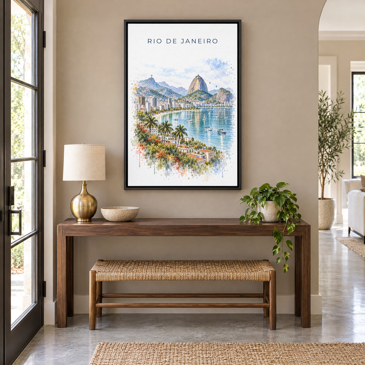 Rio de Janeiro watercolor print as a black floater canvas above a walnut console and woven bench in an entryway