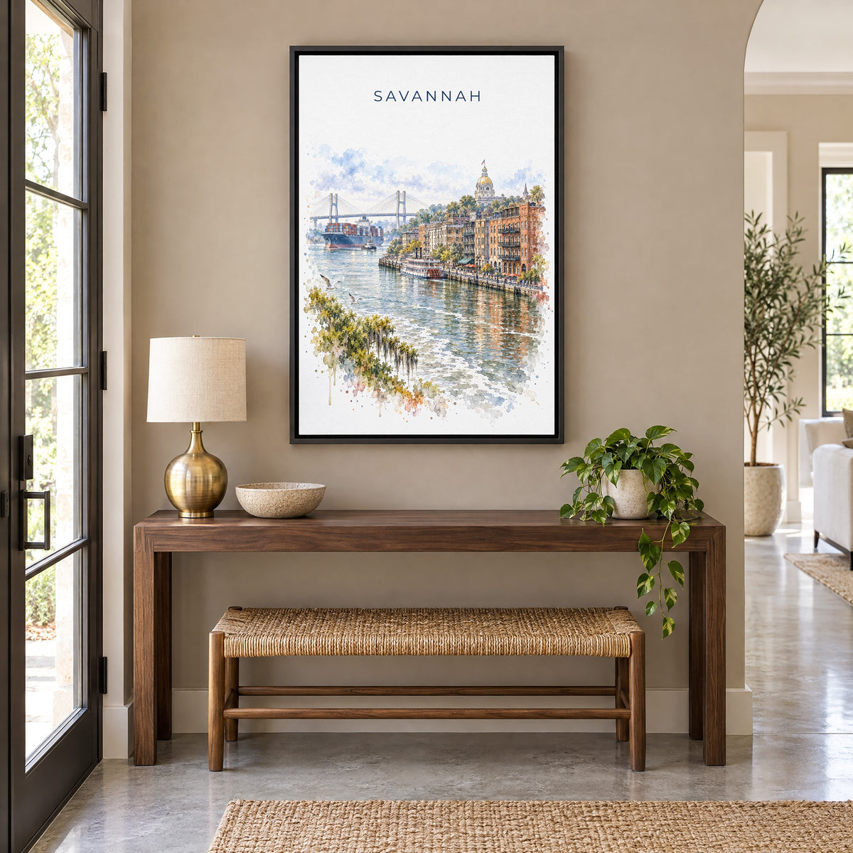 River Street Savannah watercolor print as a black floater canvas above a walnut console and woven bench in an entryway