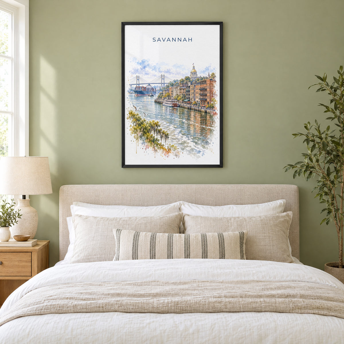 River Street Savannah watercolor print in a black frame above an upholstered headboard in a sage green bedroom