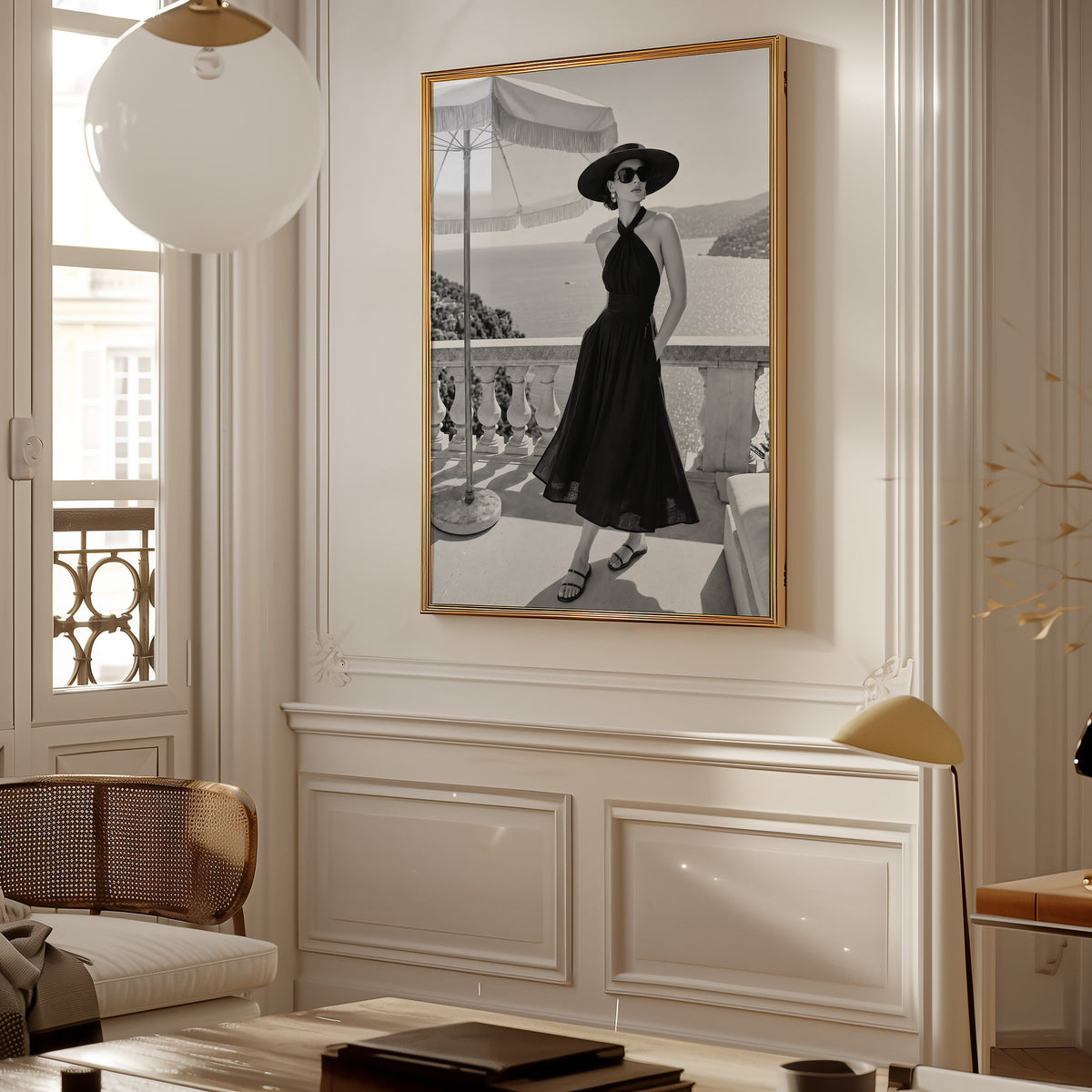 Black and white woman in halter dress on terrace print shown in a gold frame in a Parisian paneled living room