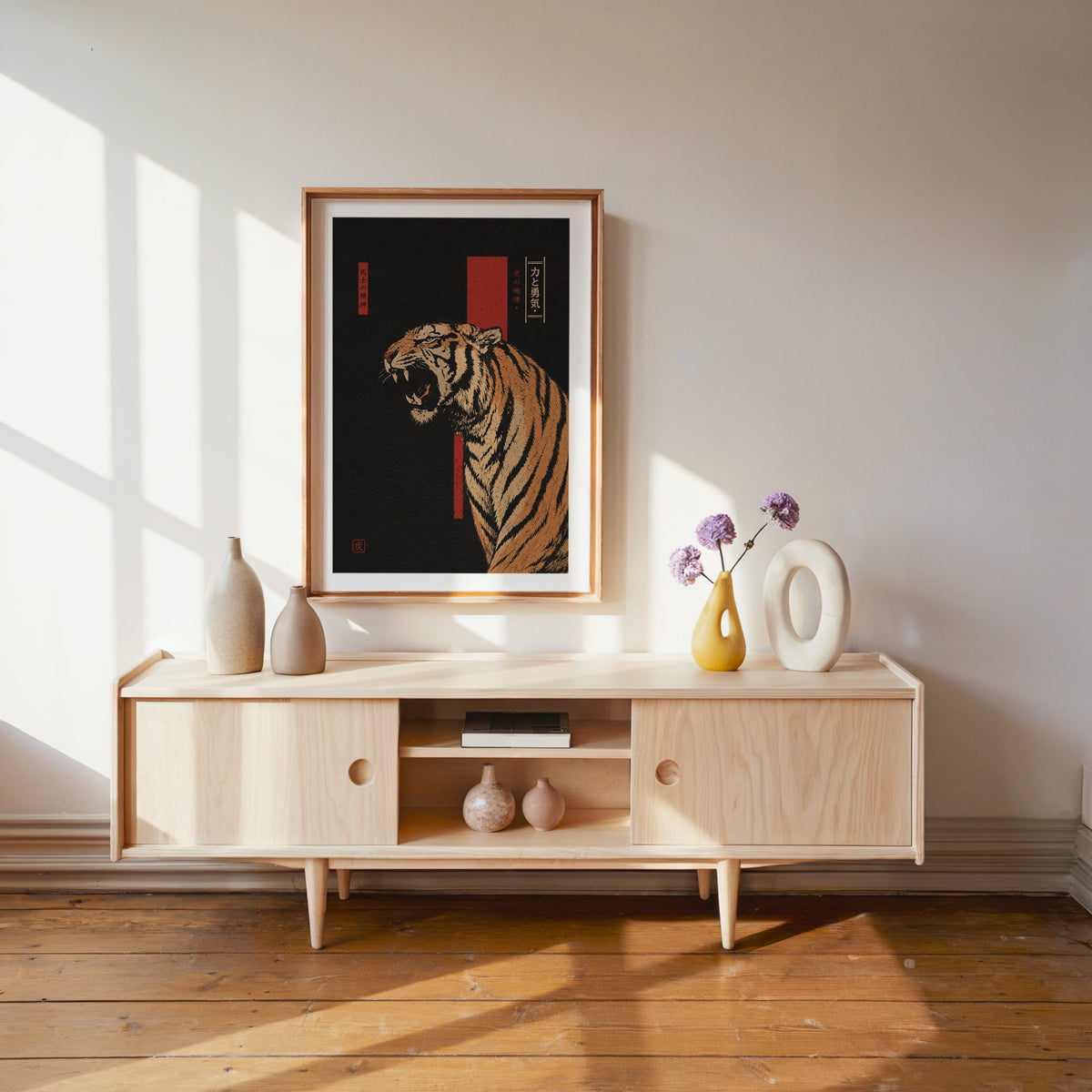 roaring tiger on black with red banner print shown in a wood frame with a white mat above a pale wood media console