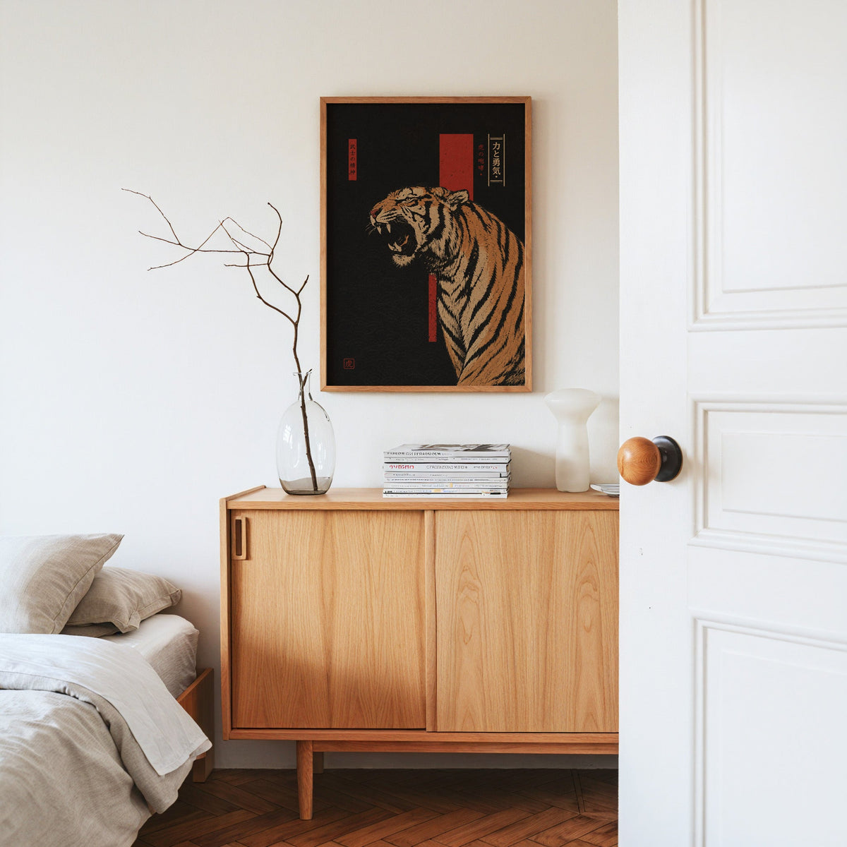 roaring tiger on black with red banner print in an oak frame above an oak sideboard in a bedroom with linen bedding