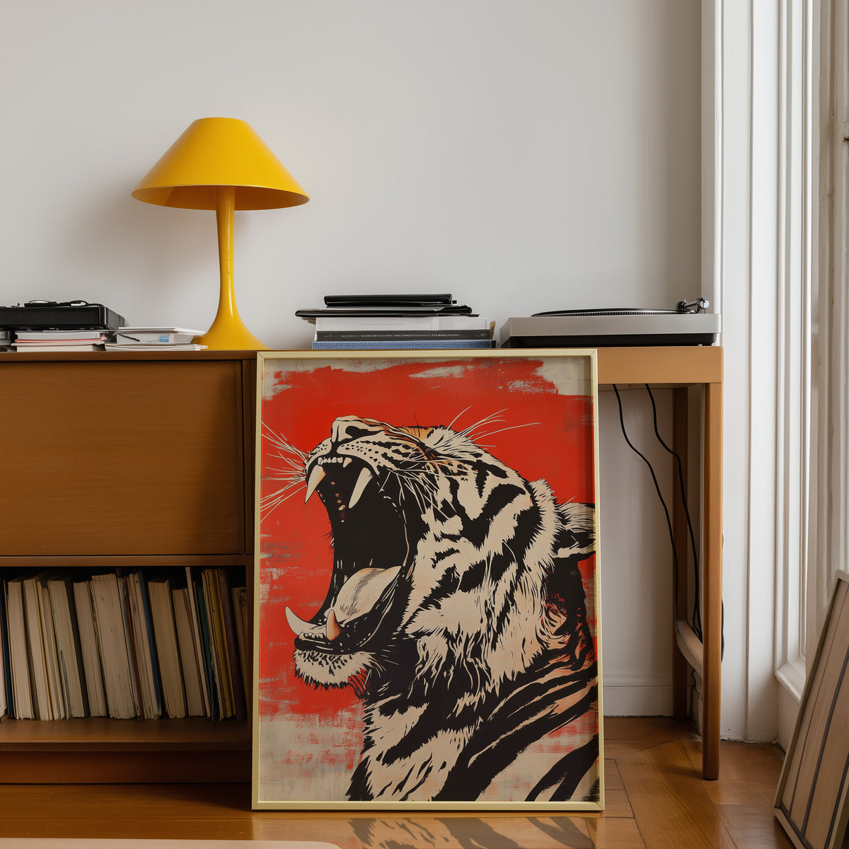 Roaring tiger head in profile print shown in a gold frame below a teak desk with a yellow lamp
