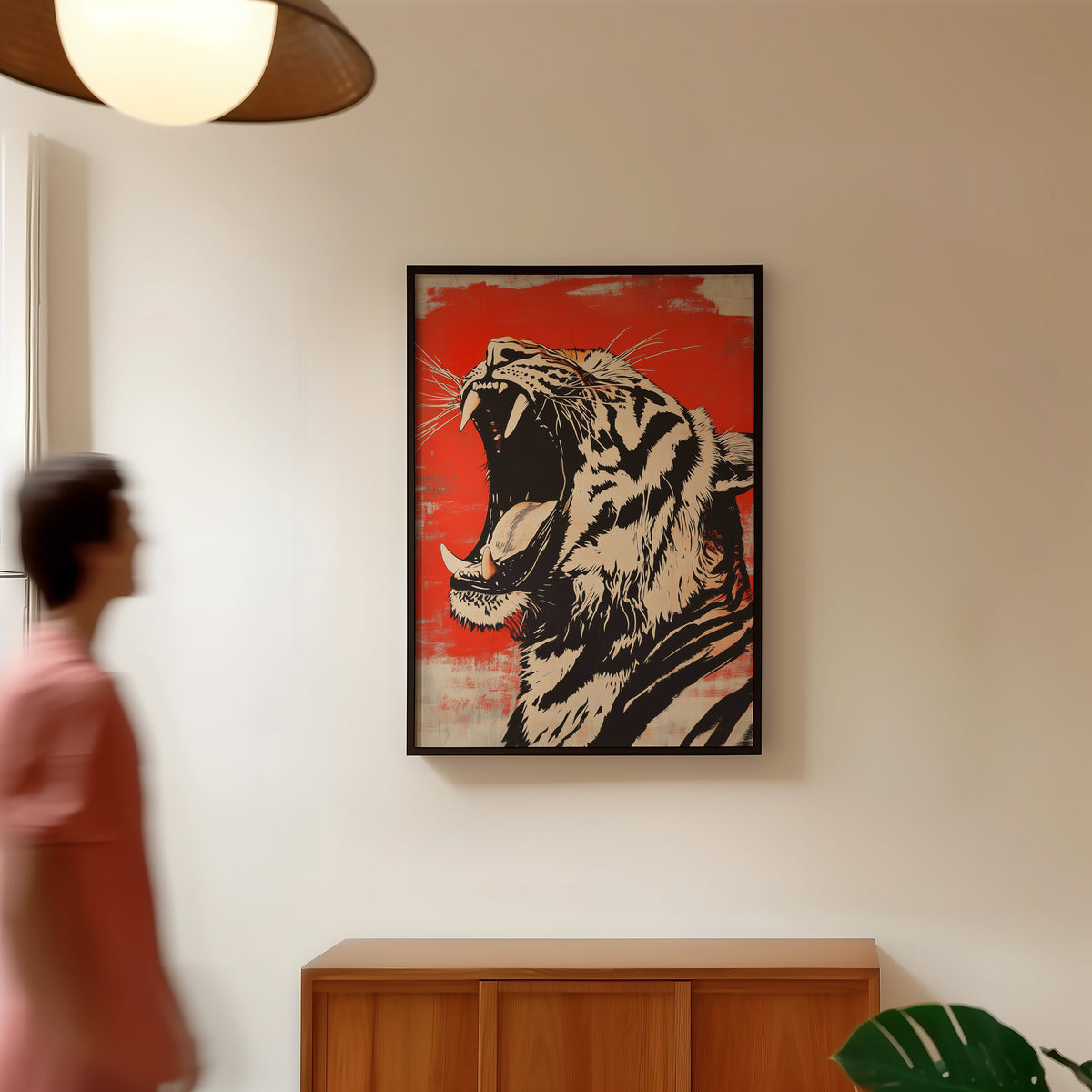 Roaring tiger head in profile print in a black frame in a hallway under a rattan pendant