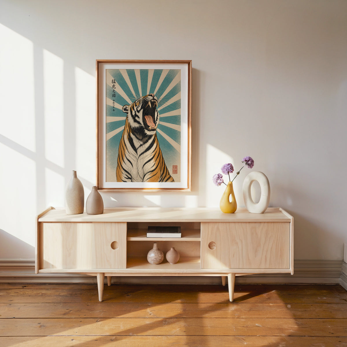 roaring tiger with teal sunburst print shown in a wood frame with a white mat above a pale wood media console