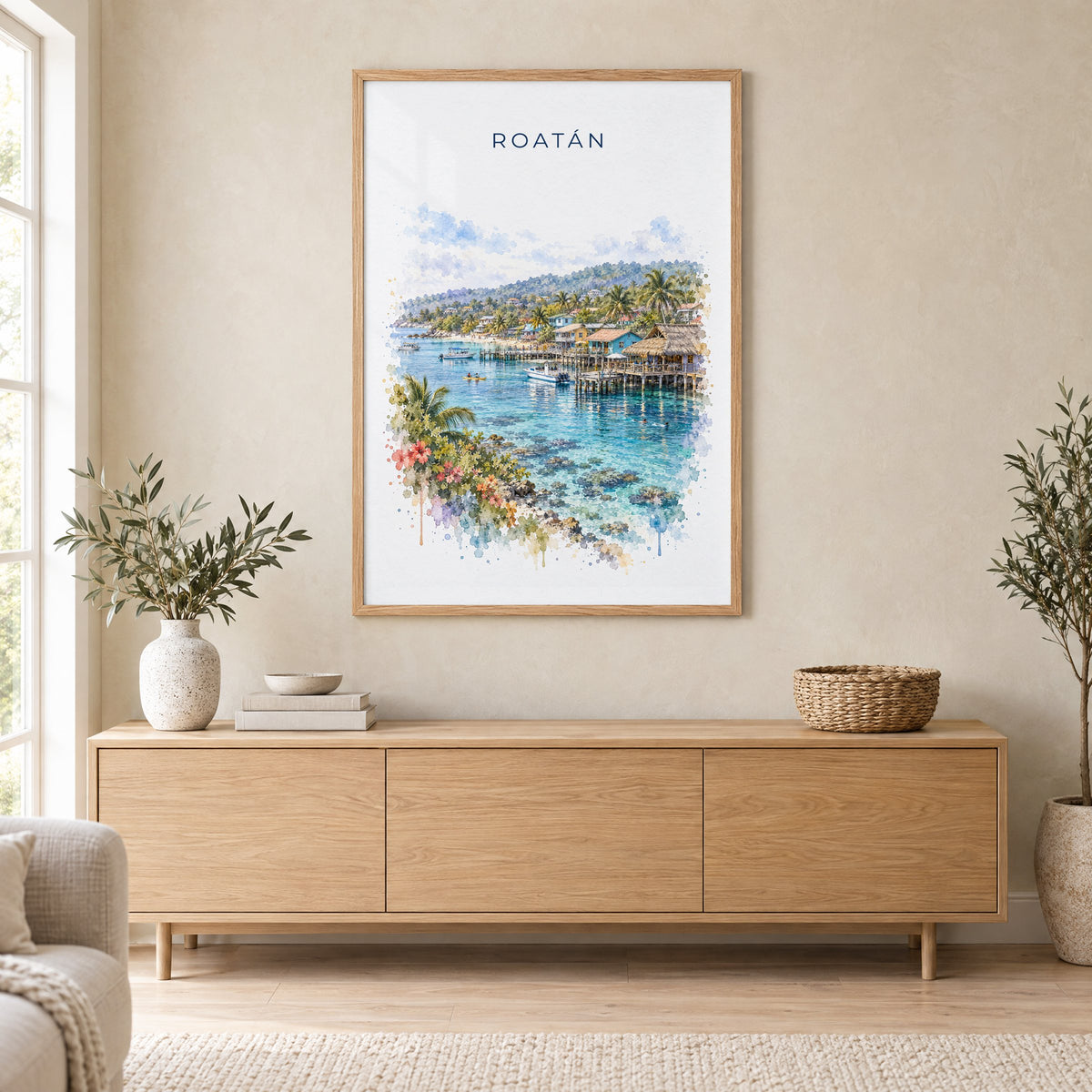 Roatan watercolor print in an oak frame above a light wood sideboard in a Scandinavian living room
