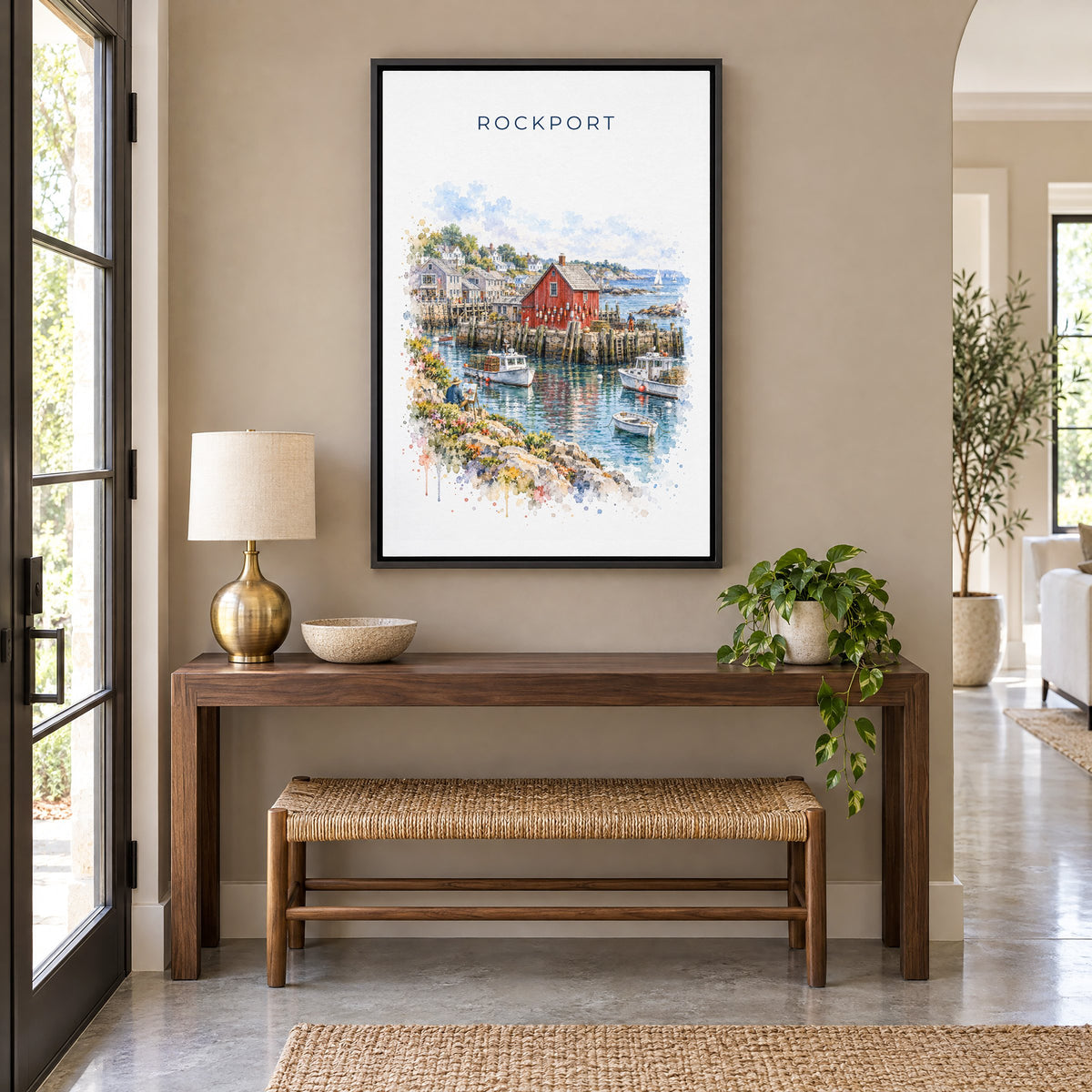 Rockport, Massachusetts watercolor print as a black floater canvas above a walnut console and woven bench in an entryway