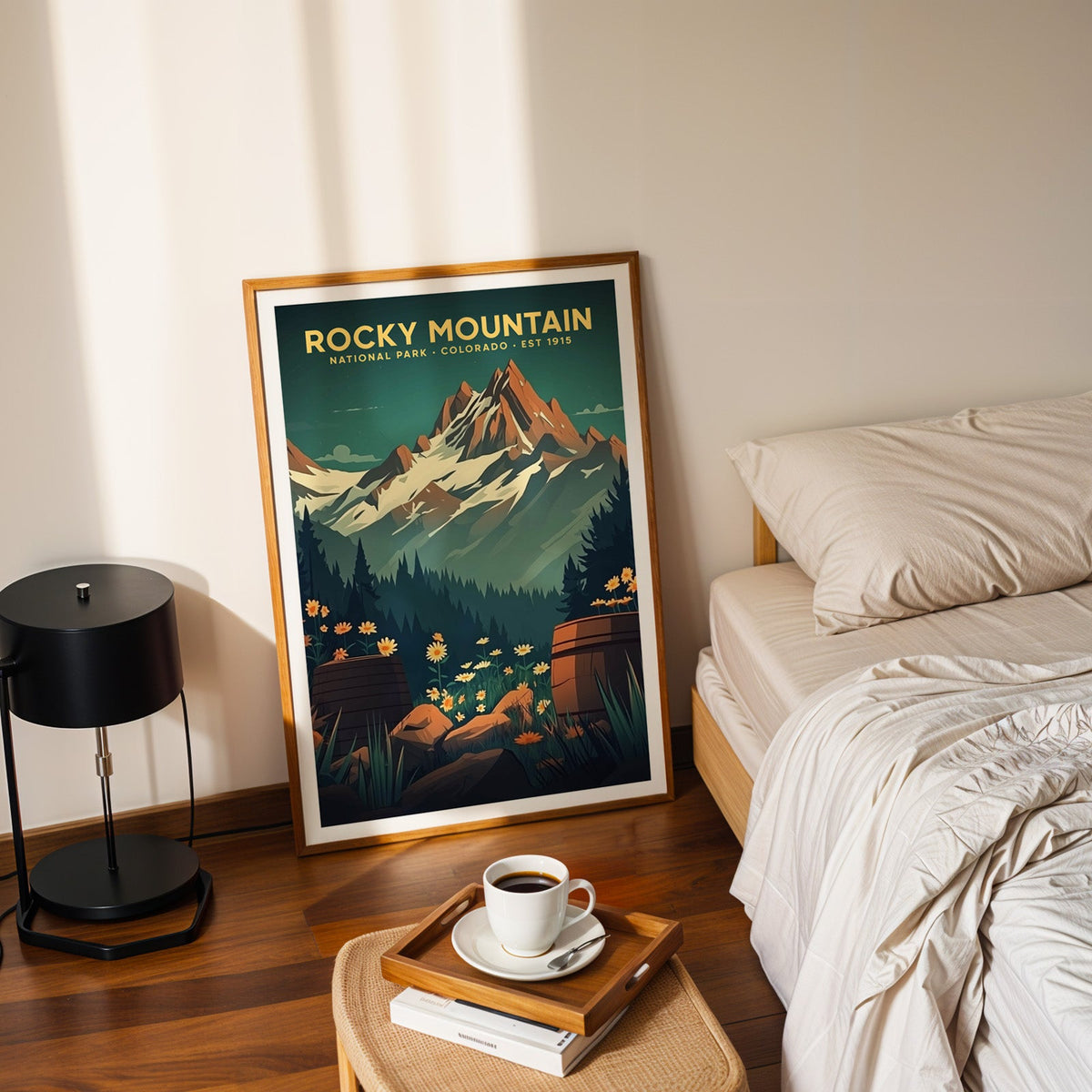 Rocky Mountain National Park print in an oak frame leaning on a bedroom floor beside the bed and a tray