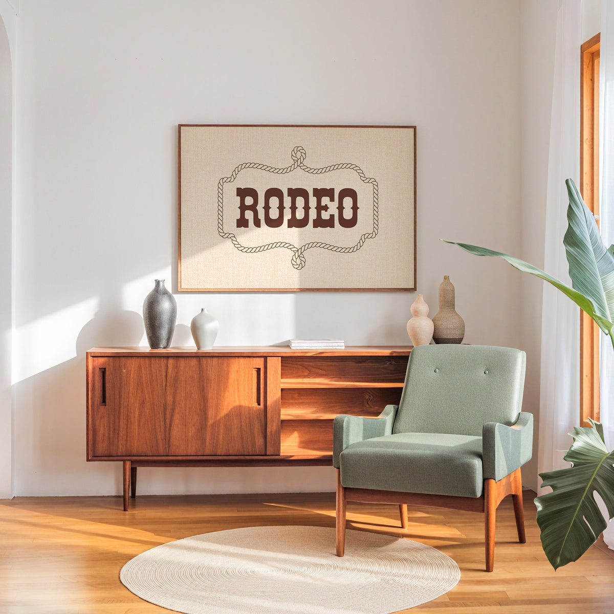 Rodeo rope frame type print in a walnut frame above a sideboard beside a sage armchair