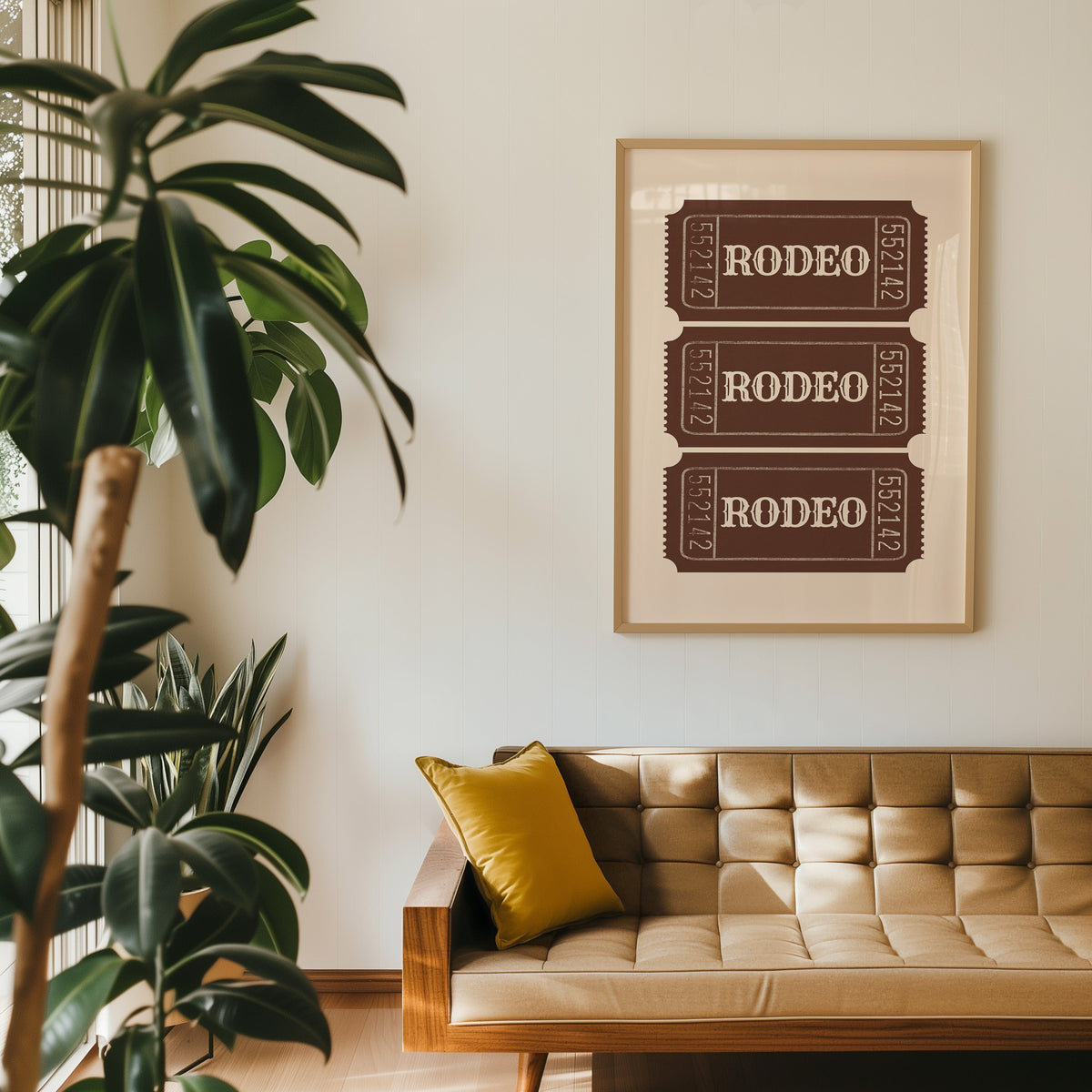 Rodeo ticket print in an oak frame above a tan leather sofa