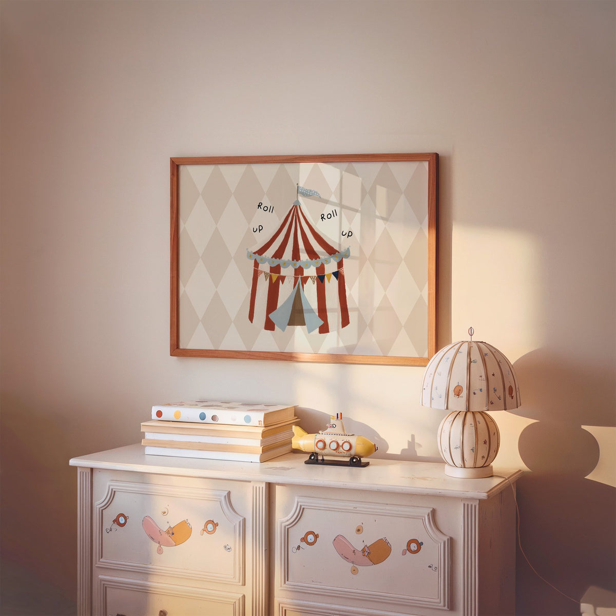 Landscape roll up circus tent nursery print in a cherry wood frame above a painted dresser and lamp
