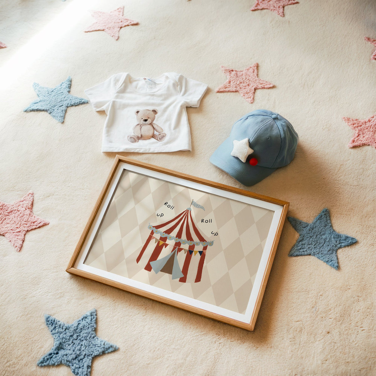 Landscape roll up circus tent nursery print in a matted oak frame on a star rug with a baby tee