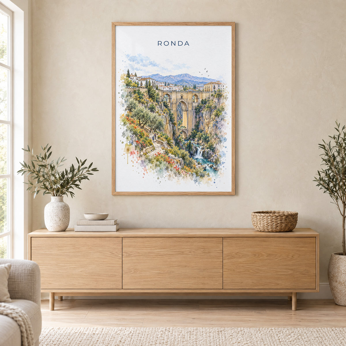 Ronda watercolor print in an oak frame above a light wood sideboard in a Scandinavian living room