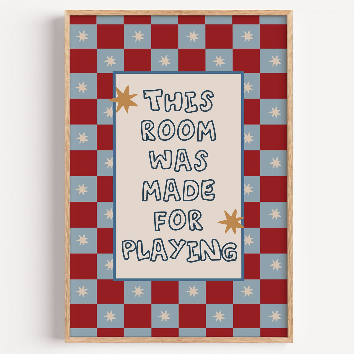 Room made for playing checkered nursery print in a light oak frame on a plain white wall