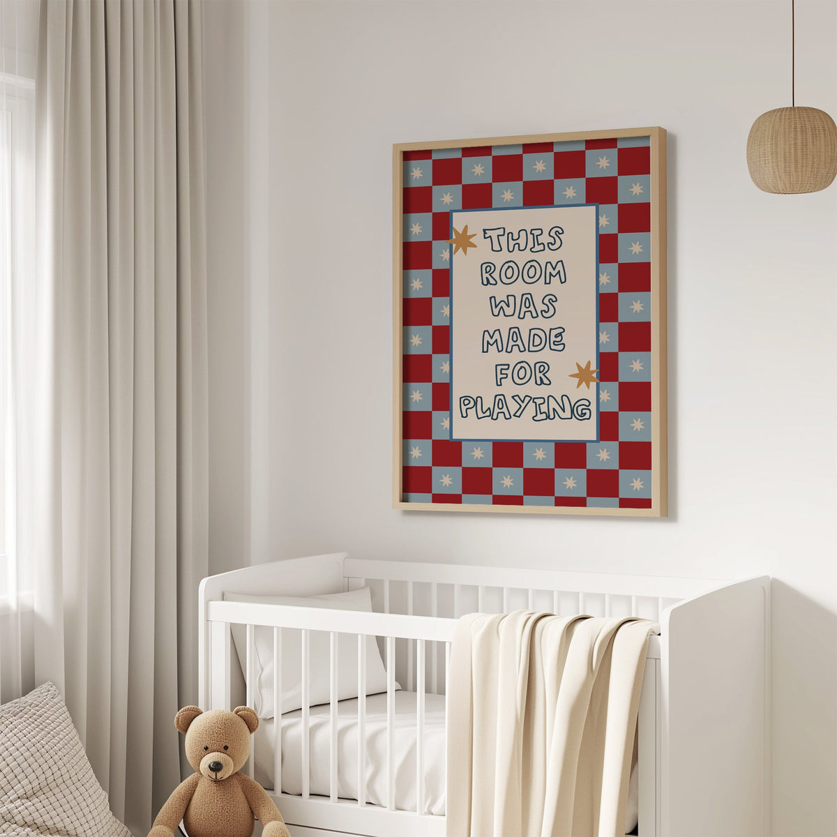 Room made for playing checkered nursery print in an oak frame above a white crib with a teddy bear