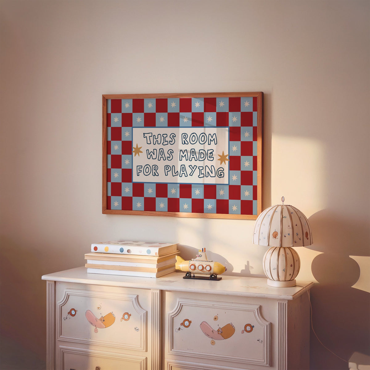 Landscape room made for playing checkered nursery print in a cherry wood frame above a painted dresser and lamp
