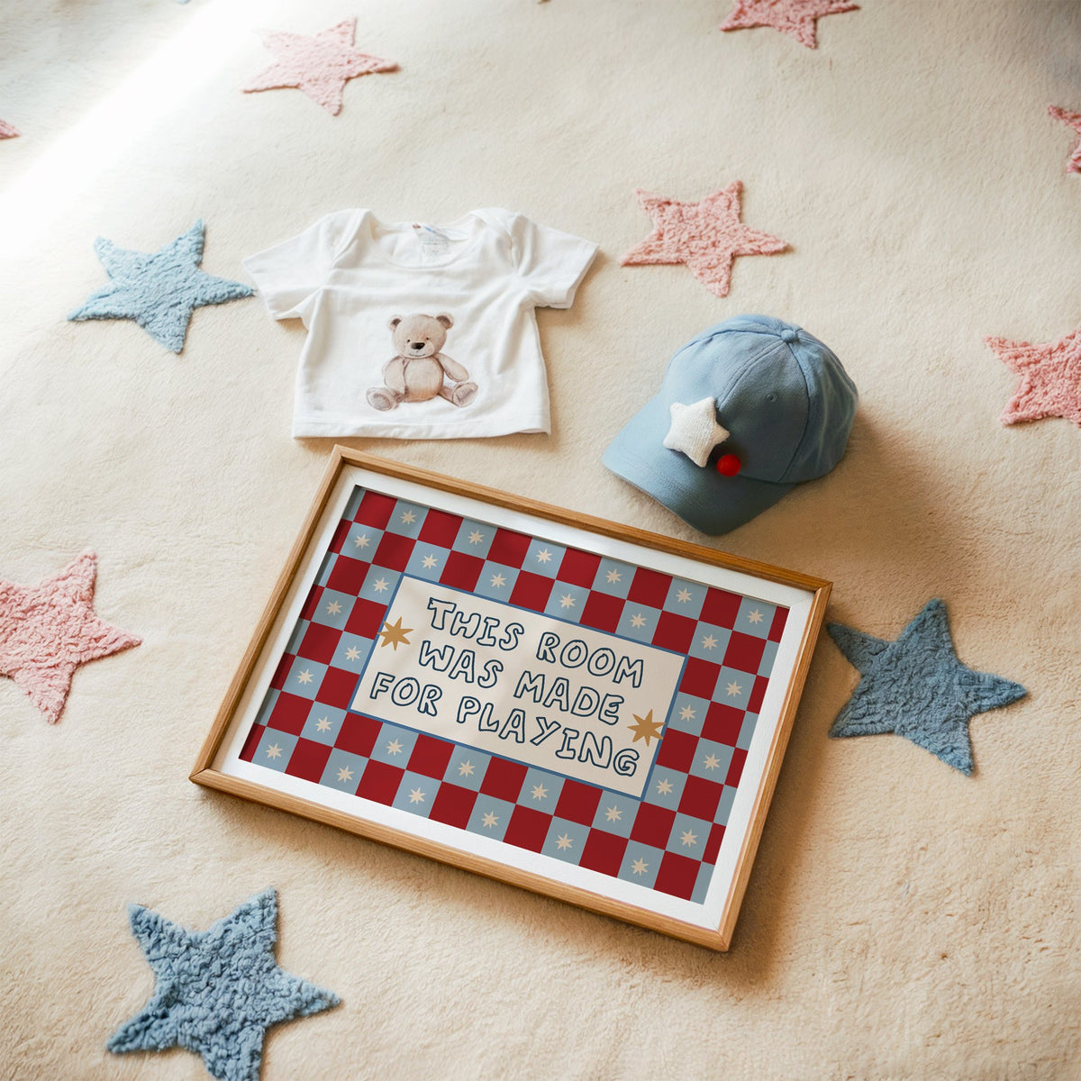 Landscape room made for playing checkered nursery print in a matted oak frame on a star rug with a baby tee