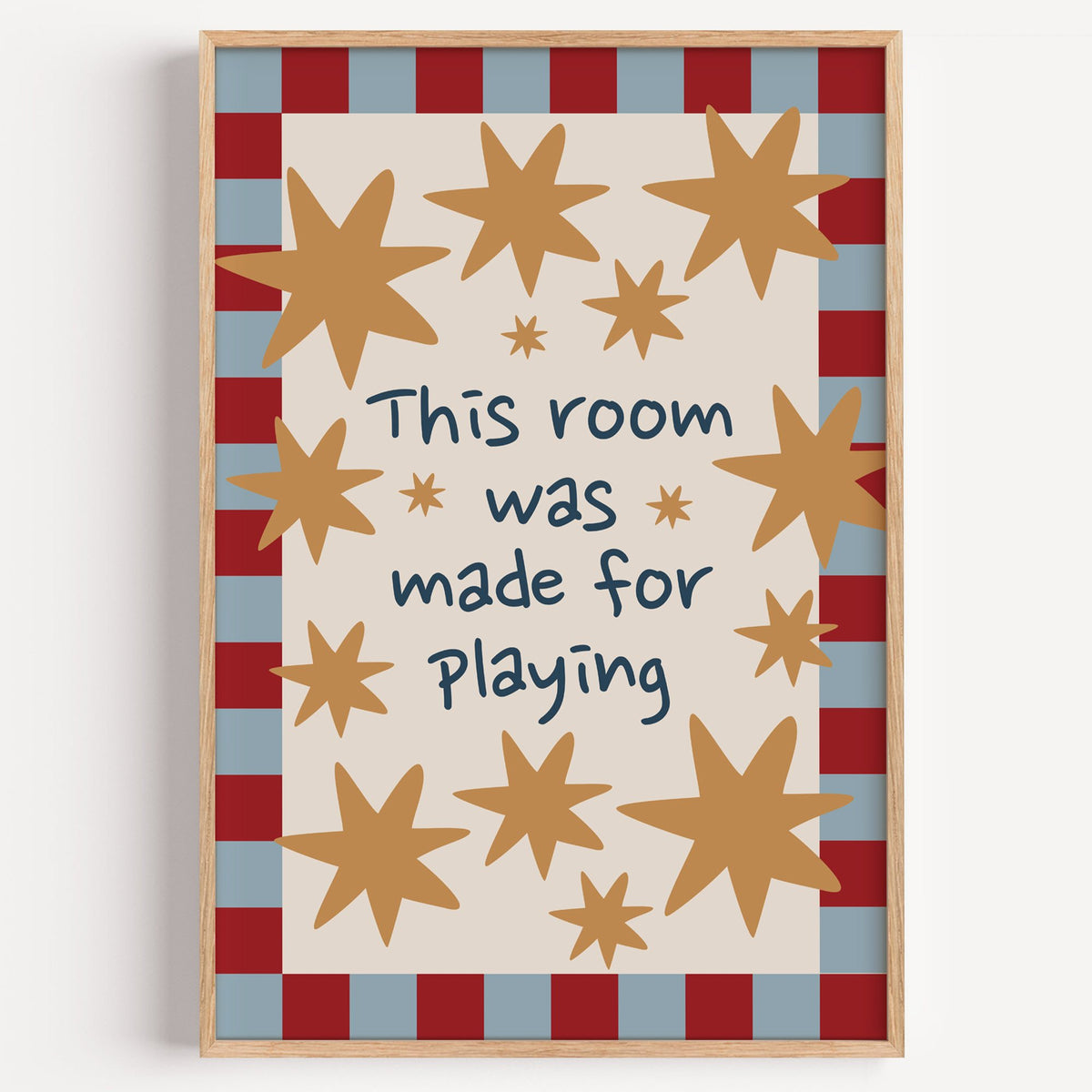 Room made for playing stars nursery print in a light oak frame on a plain white wall