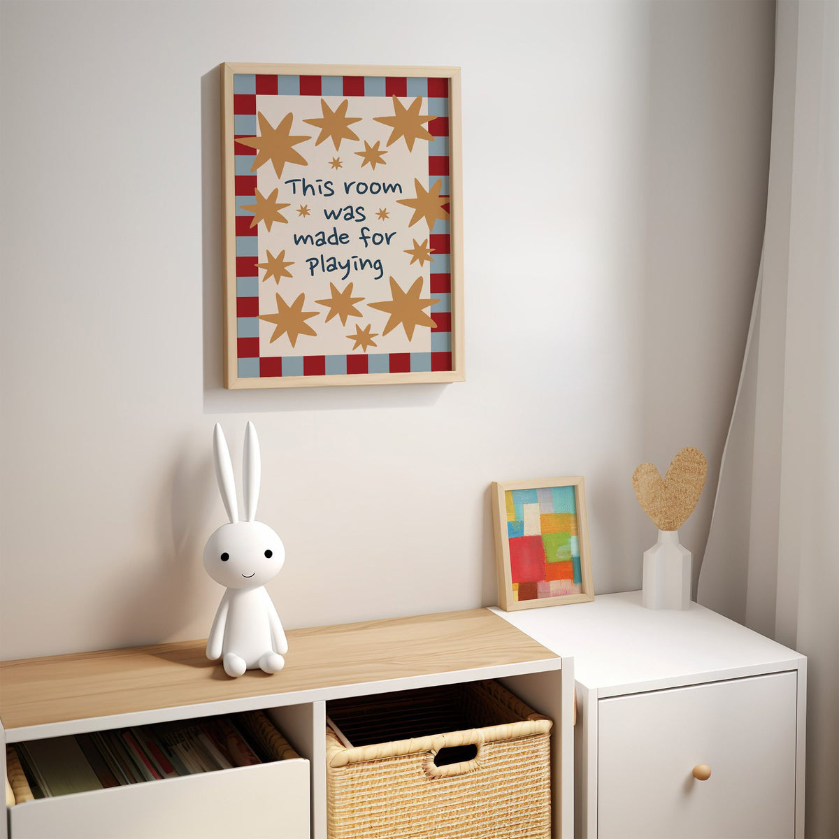 Room made for playing stars nursery print in an oak frame above a kids cubby shelf with a woven basket and bunny lamp