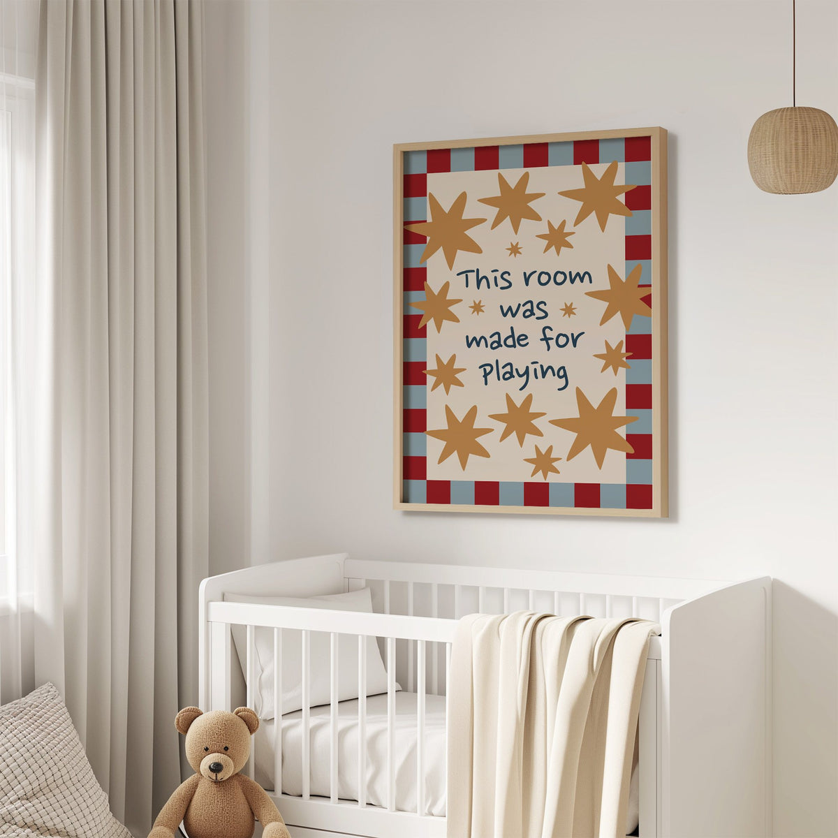 Room made for playing stars nursery print in an oak frame above a white crib with a teddy bear
