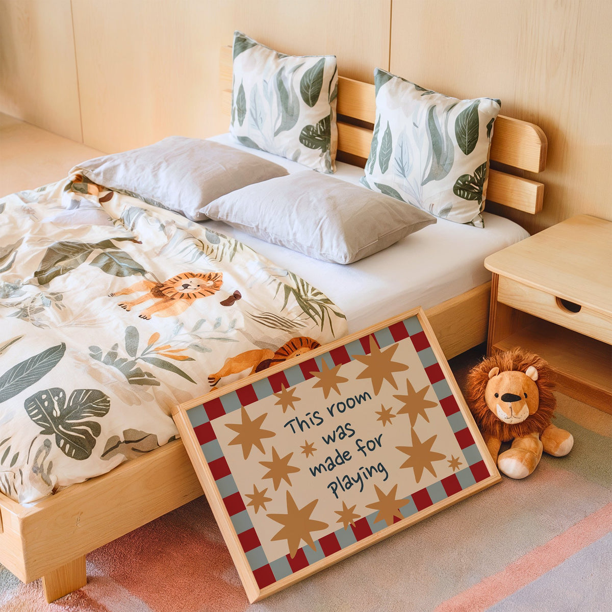 Landscape room made for playing stars nursery print in an oak frame leaning on a kids bed by a lion plush