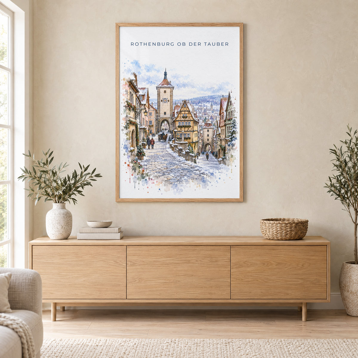 Rothenburg ob der Tauber watercolor print in an oak frame above a light wood sideboard in a Scandinavian living room