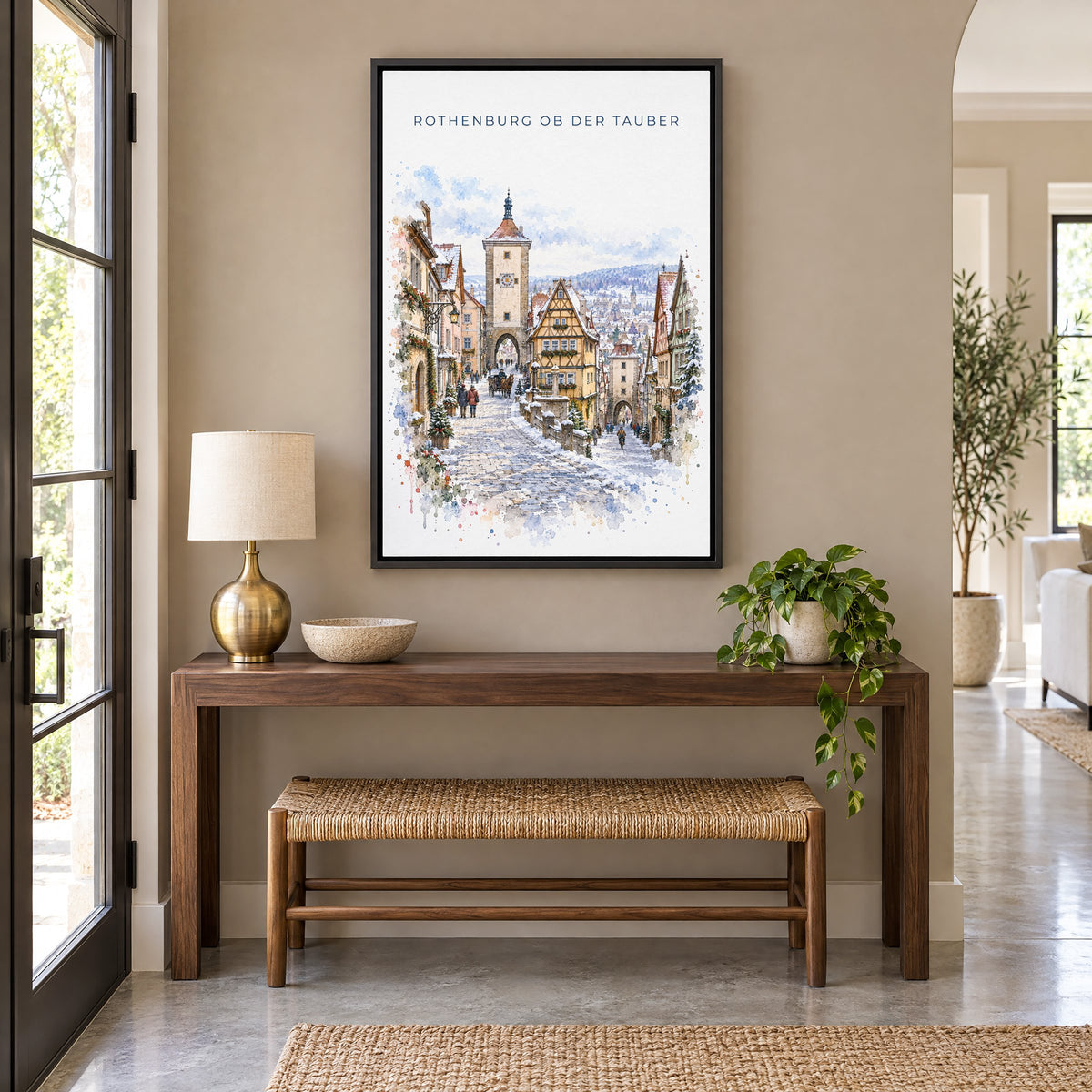 Rothenburg ob der Tauber watercolor print as a black floater canvas above a walnut console and woven bench in an entryway
