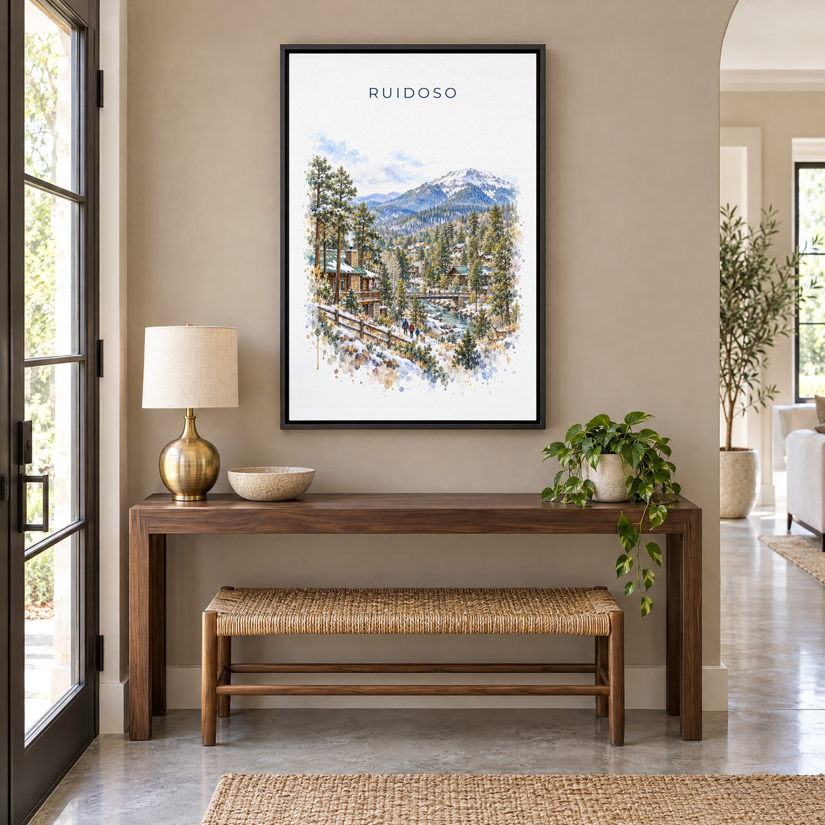 Ruidoso, New Mexico watercolor print as a black floater canvas above a walnut console and woven bench in an entryway