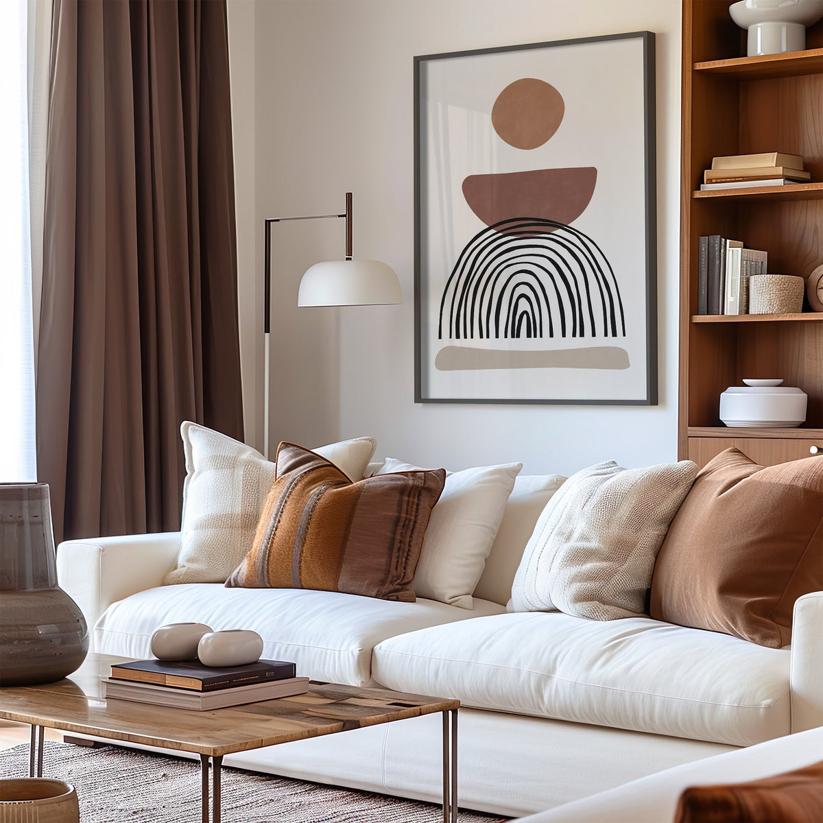 Rust bowl and black wobbly arch boho print in a black frame above a cream sofa with brown striped pillows