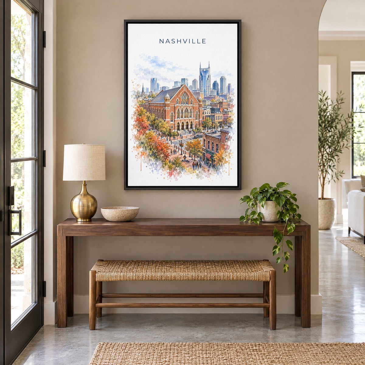 Ryman Auditorium watercolor print as a black floater canvas above a walnut console and woven bench in an entryway