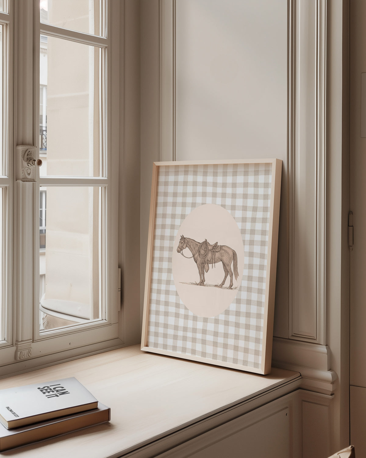 Saddled horse print in a pale wood frame on a sunlit window ledge