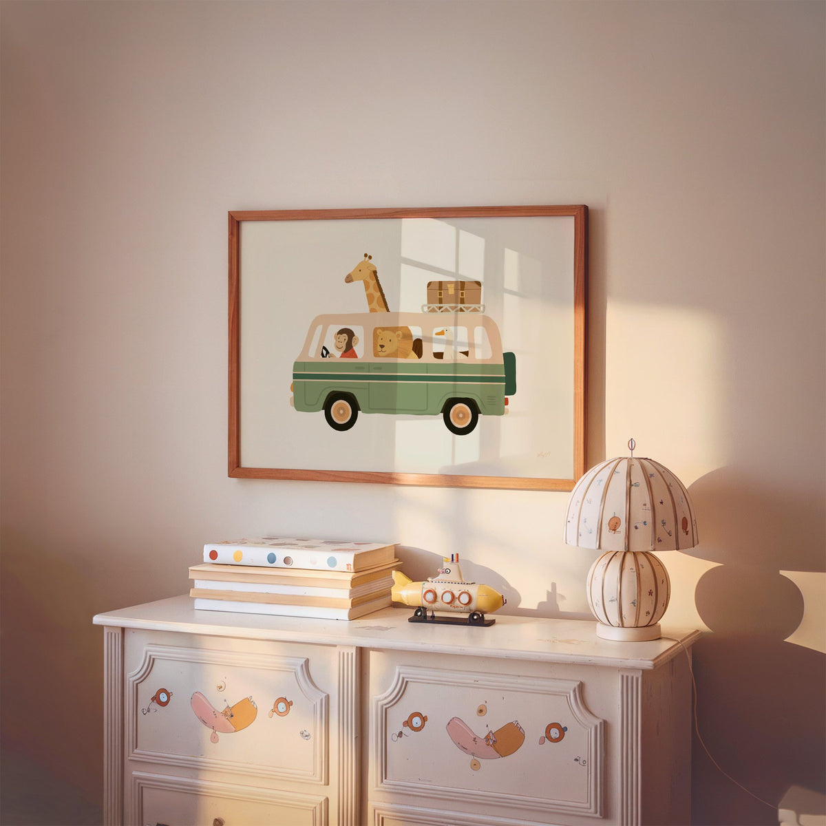Safari animals riding green van nursery print in a cherry wood frame above a painted dresser and lamp