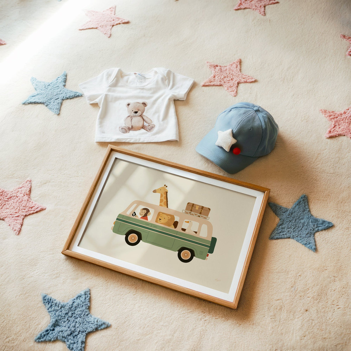 Safari animals riding green van nursery print in a matted oak frame on a star rug with a baby tee