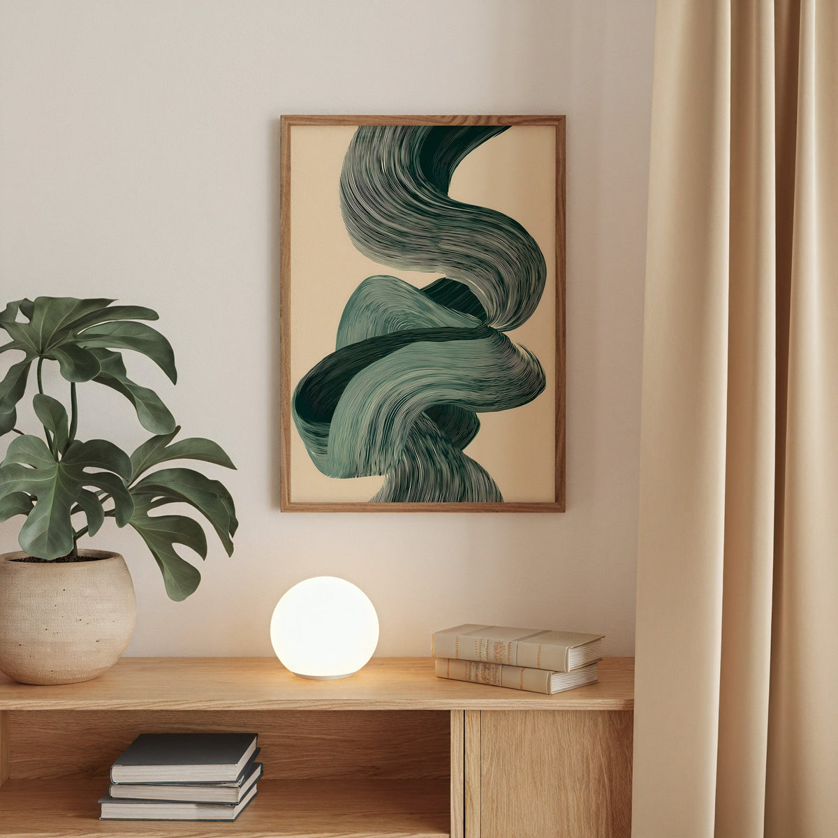 Sage green line ribbon swirl abstract print in a walnut frame above an oak cabinet with a glowing globe lamp