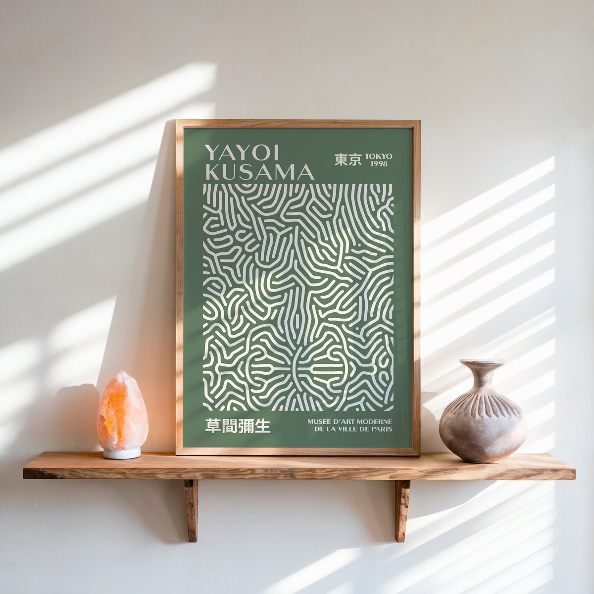 Yayoi Kusama inspired sage squiggle on deep green print above a shelf with a salt lamp