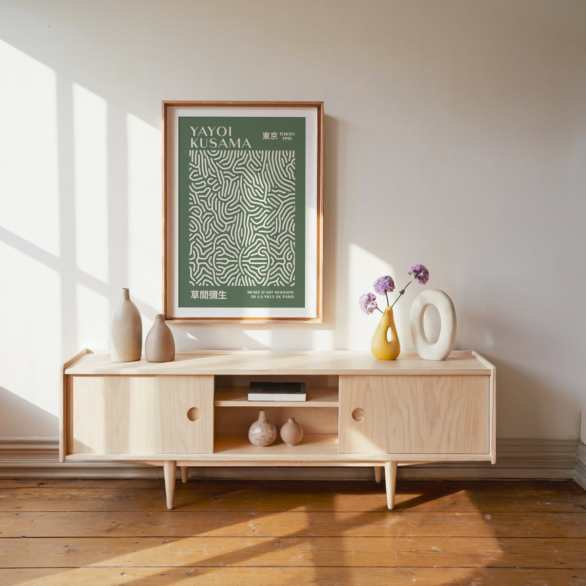 Yayoi Kusama inspired sage squiggle on deep green print above a pale wood console