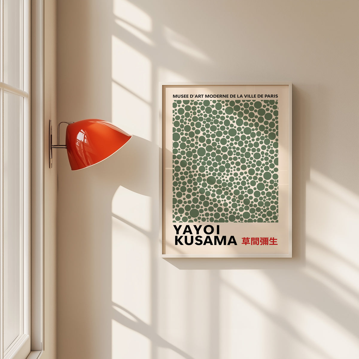 Yayoi Kusama inspired sage green polka dot print in a white frame by a red wall lamp