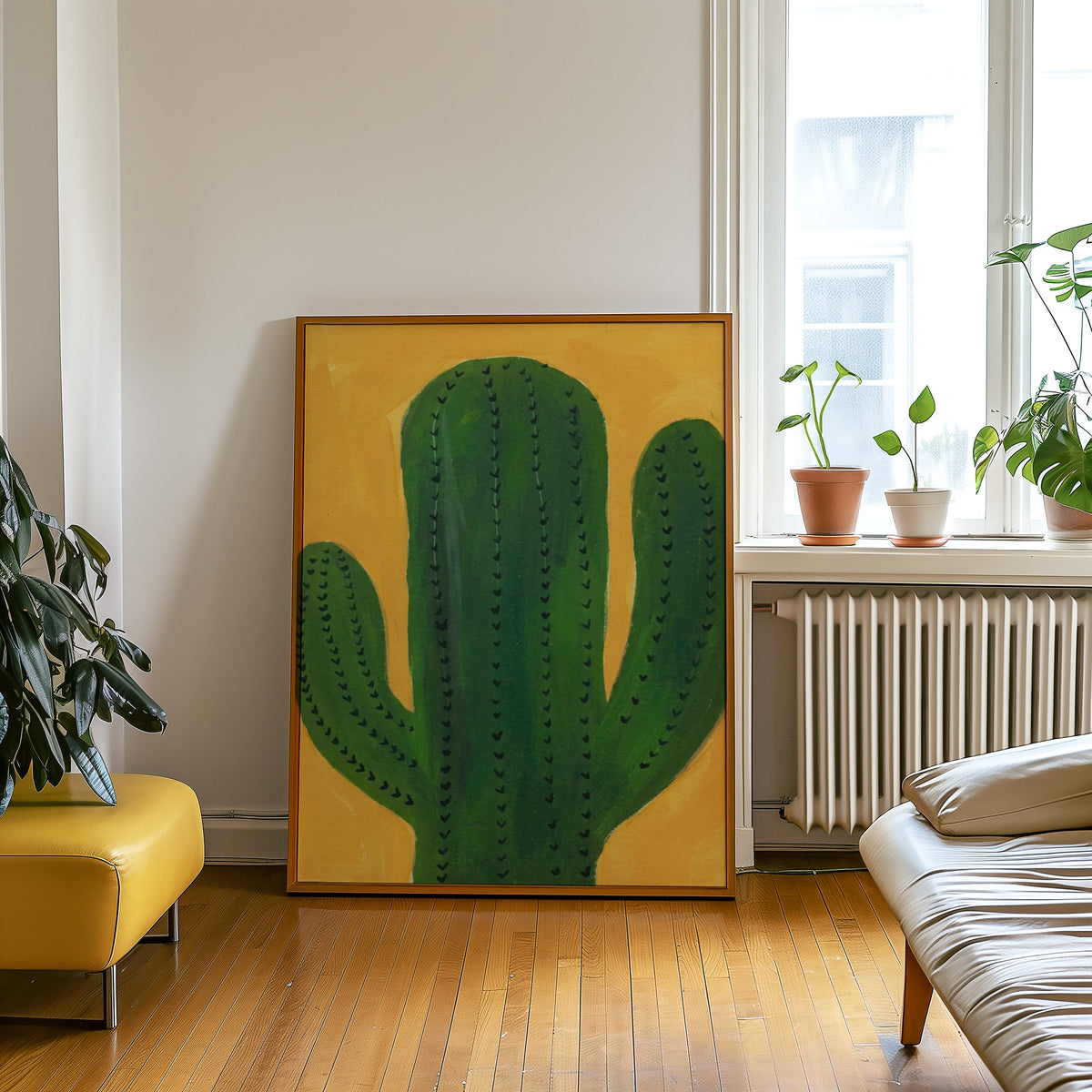 Boho cactus wall art print in an oak frame leaning beside a yellow leather bench