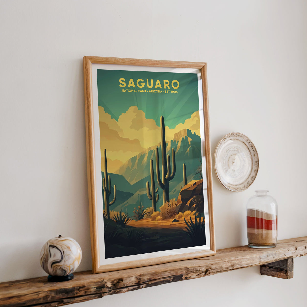 Saguaro National Park print in an oak frame on a rustic wood shelf with ceramics and a sand-filled jar